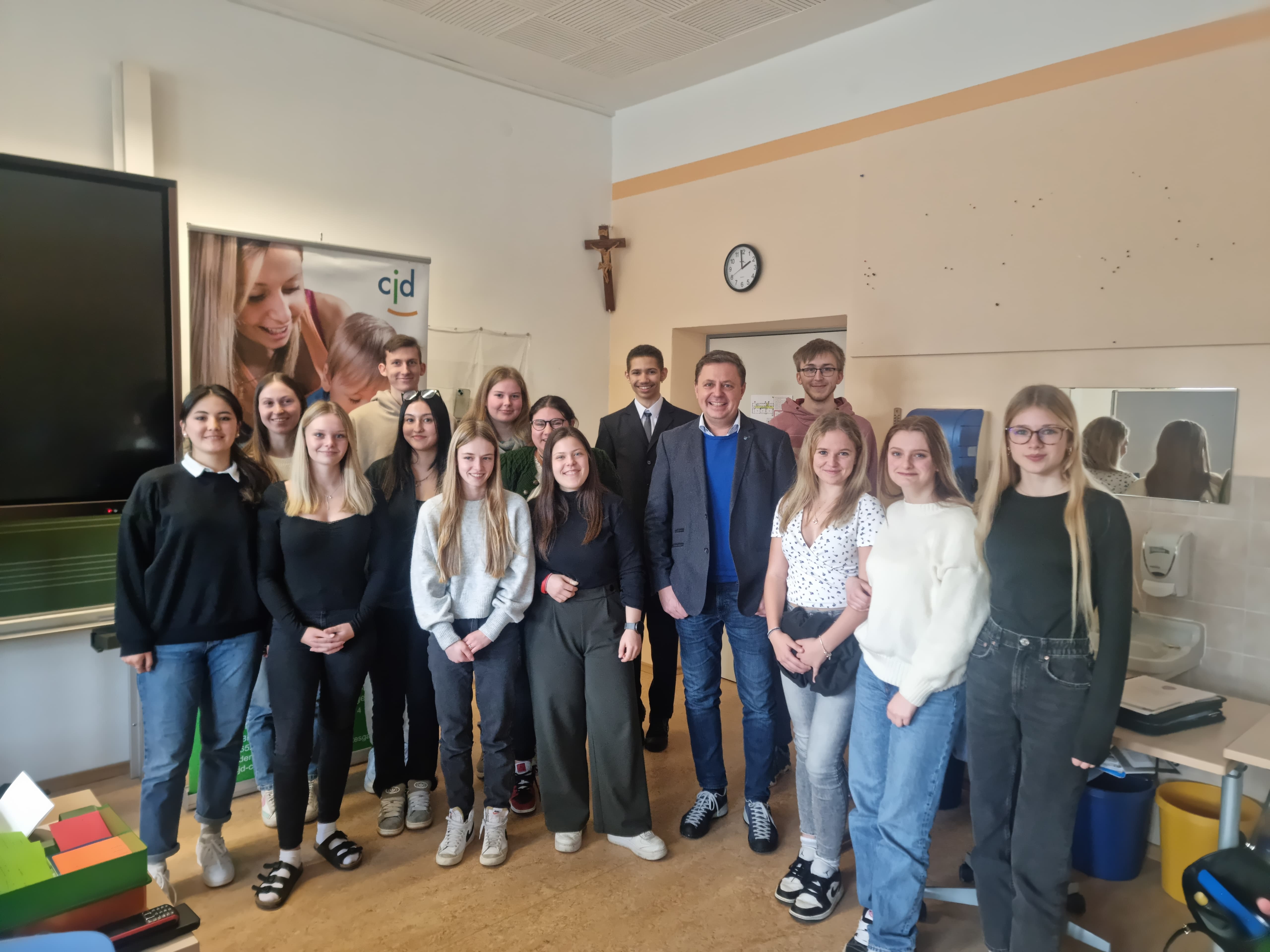 Klassenfoto mit einigen der Schülerinnen und Schuler der CJD Berufsfachschule für Kinderpflege mit Herrn Koller, sowie der Zeugnisübergabe durch Frau Ennemoser-Schurich.
